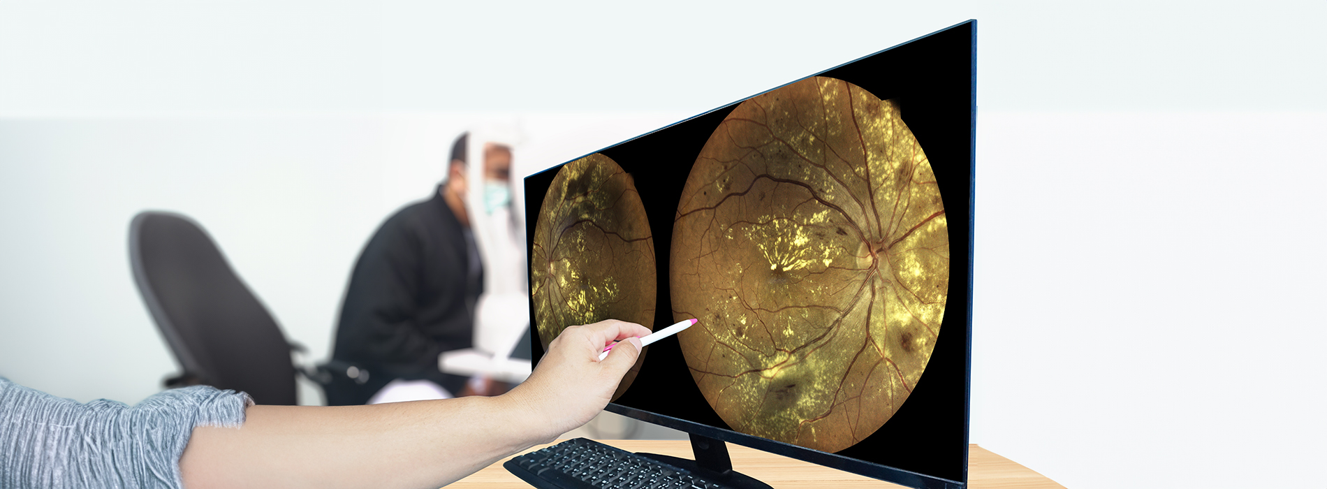 The image shows a person s hands holding a tablet with a digital illustration of a celestial scene, featuring a planet with rings and a large moon in the background, set against a blurred indoor office environment.